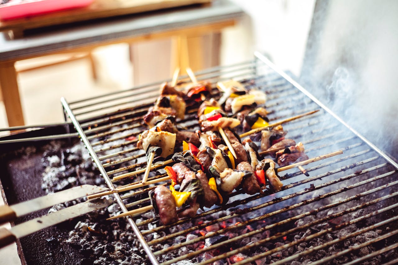 Savory grilled skewers with meat and vegetables sizzling over hot charcoal, perfect for outdoor cooking.